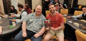 Greg Raymer and Paul Beitelspacher posing with Raymer's poker book at the Mixed Game Festival at Resorts World in Las Vegas, Nevada.